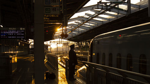 Conductor standing by train at railroad station platform