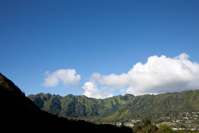 Scenic view of mountains against blue sky