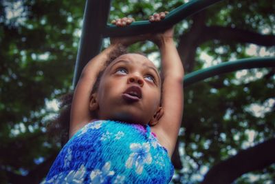 Low angle view of girl on play equipment