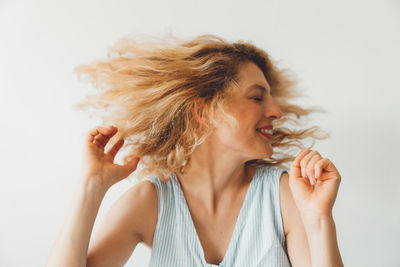 Close-up of young woman looking away against white background