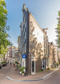 Road by buildings against sky in city