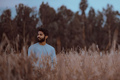 Man standing on field against trees