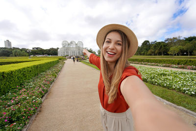 Beautiful smiling girl takes self portrait in the botanical garden of curitiba, parana, brazil.