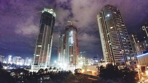 Low angle view of illuminated skyscrapers against sky at night