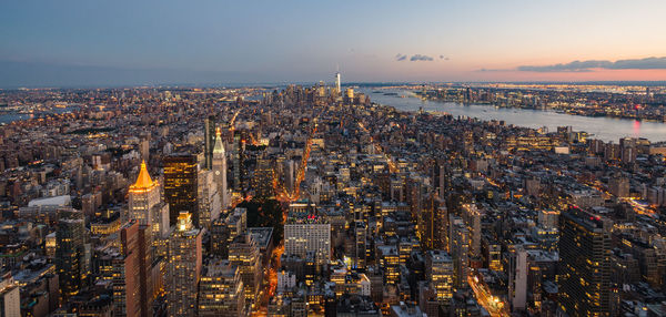 High angle view of city lit up at sunset