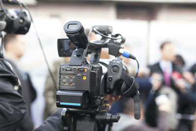 Cropped hands of male tv reporter holding television camera