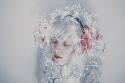 Close-up of woman with dyed hair against white background