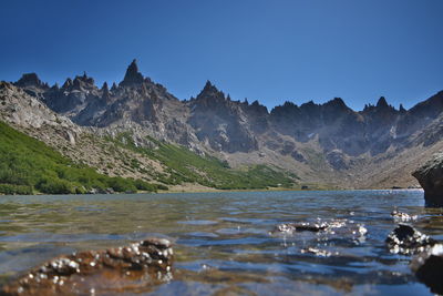 Scenic view of lake and mountains against clear sky