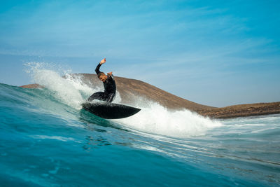 Man surfing on sea against sky