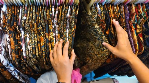 High angle view of woman choosing clothes from rack at store