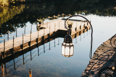 Close-up of padlocks hanging on bridge over lake