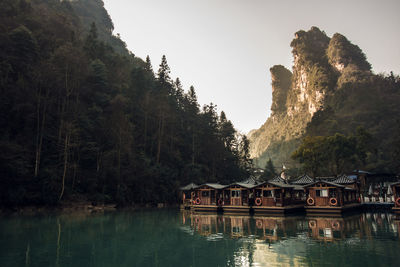 Scenic view of boathouses in lake mountains against sky