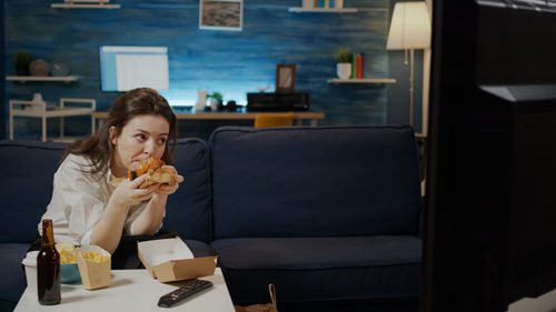 Young woman eating food at home