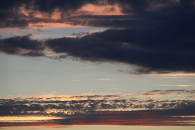 Low angle view of dramatic sky over sea during sunset