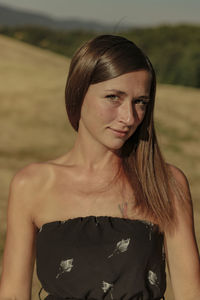 Portrait of beautiful woman standing on land during sunny day