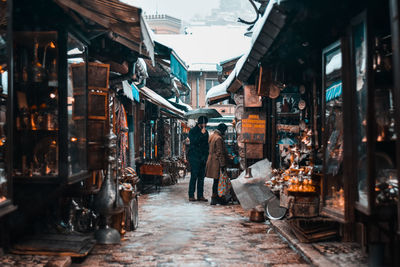 People at illuminated market in city at night