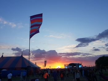 People flag against sky at sunset