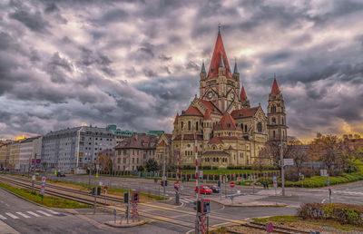 Buildings in city against cloudy sky