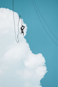 Low angle view of jumping hanging against sky