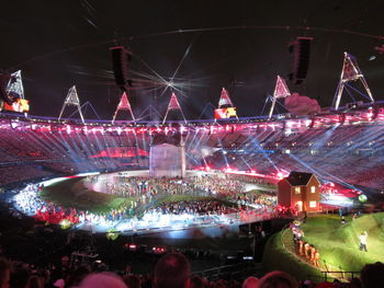 Crowd at music concert against sky at night