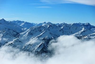 Scenic view of snow mountains against blue sky