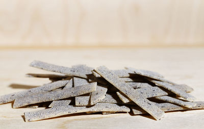 Flat ribbon pasta called pizzoccheri made with buckwheat flour and wheat flour on brown background