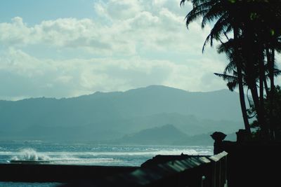 Scenic view of sea and silhouette mountains against sky
