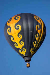 Low angle view of hot air balloon against clear blue sky