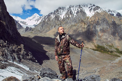 Young woman standing on snowcapped mountains during winter
