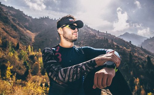 Young man wearing sunglasses standing on mountain