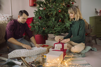 Full length of woman with christmas tree