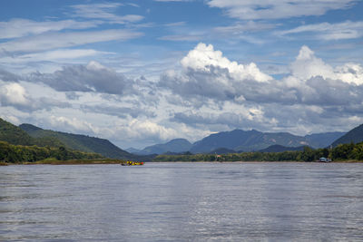 Scenic view of lake by mountains against sky