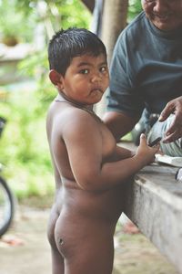 Portrait of shirtless boy standing outdoors