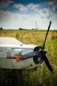 Close-up of vehicle on field against sky