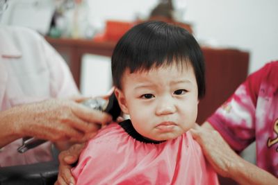 Midsection of barber trimming hair in salon