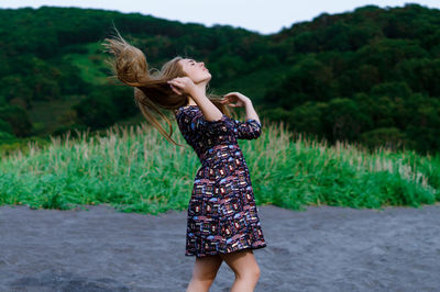 Young woman with tousled hair walking at beach