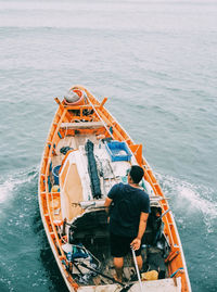 Rear view of man in boat sailing on sea