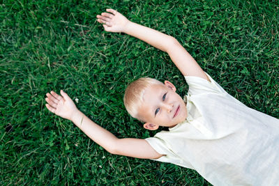 High angle view of baby lying on grassy field