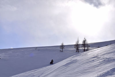 People on snow covered mountain against sky