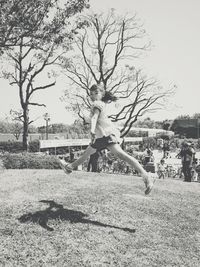 Full length of woman jumping on field