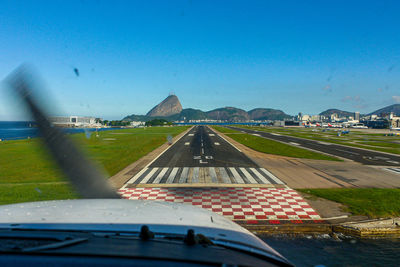 Airport runway seen through glass window of airplane