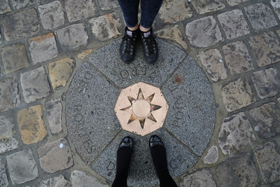 Low section of mother and daughter standing on point zero des routes de france