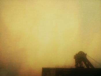 Low angle view of built structure against sky at sunset