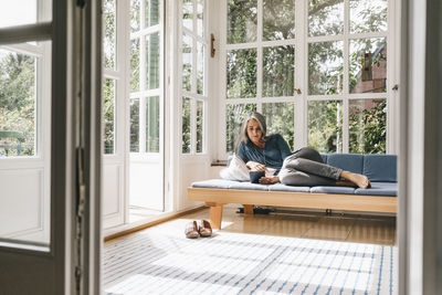 Woman sitting on table at home