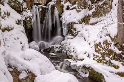 Scenic view of waterfall in forest during winter