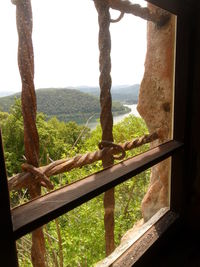 Close-up of railing by window against sky