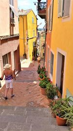 People walking on street amidst houses in city