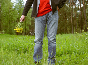 Low section of man standing on field