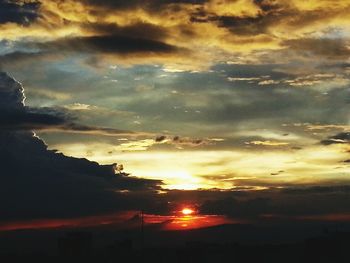 Silhouette of landscape against cloudy sky at sunset