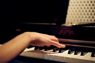 Close-up of hand playing piano